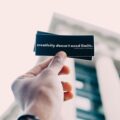 person holding black and white quote-printed card