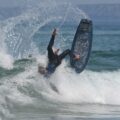 man in black wet suit riding on black surfboard during daytime