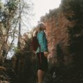 woman looking up on green trees