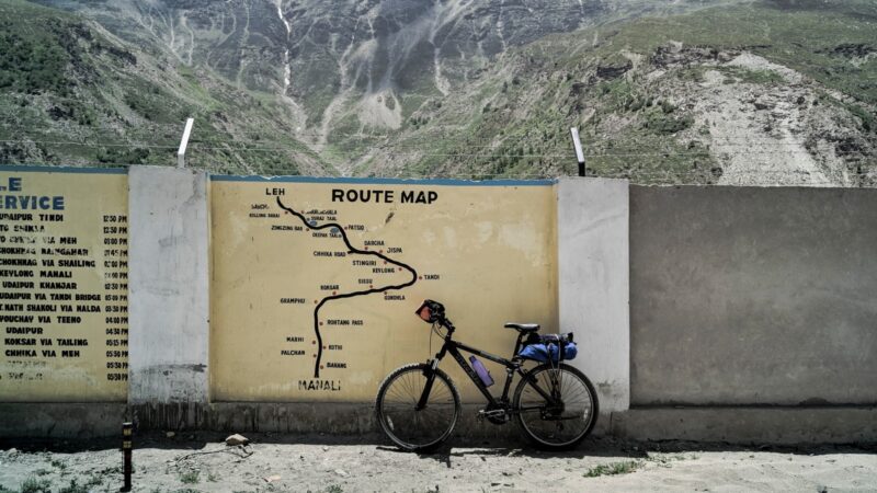 black mountain bike parked beside concrete wall