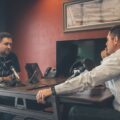 man sitting in front of another man also sitting inside room