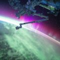 photography of purple and green aurora beam below grey space satellite