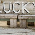 a wooden bench with the word lucky written on it