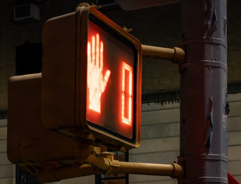 a stop light with a hand signal on it