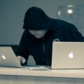 man in black hoodie using macbook