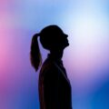 silhouette of woman wearing black hat and black coat