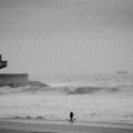 a person standing on a beach next to the ocean