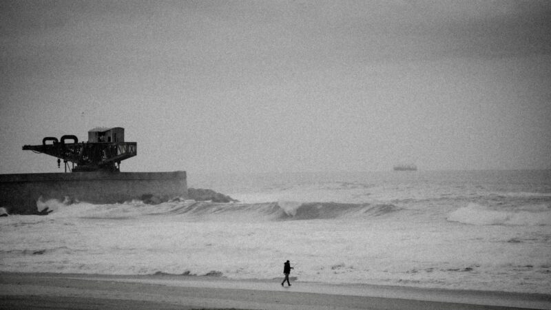 a person standing on a beach next to the ocean