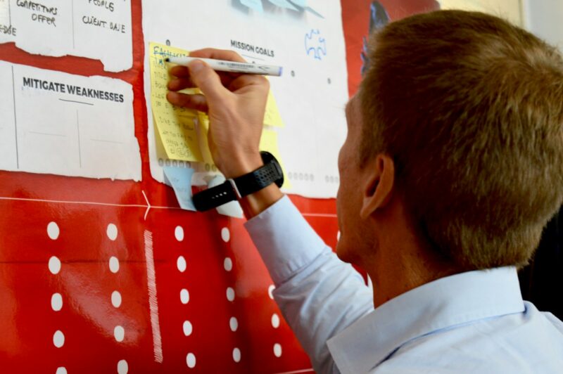 man in white dress shirt holding yellow and white labeled pack