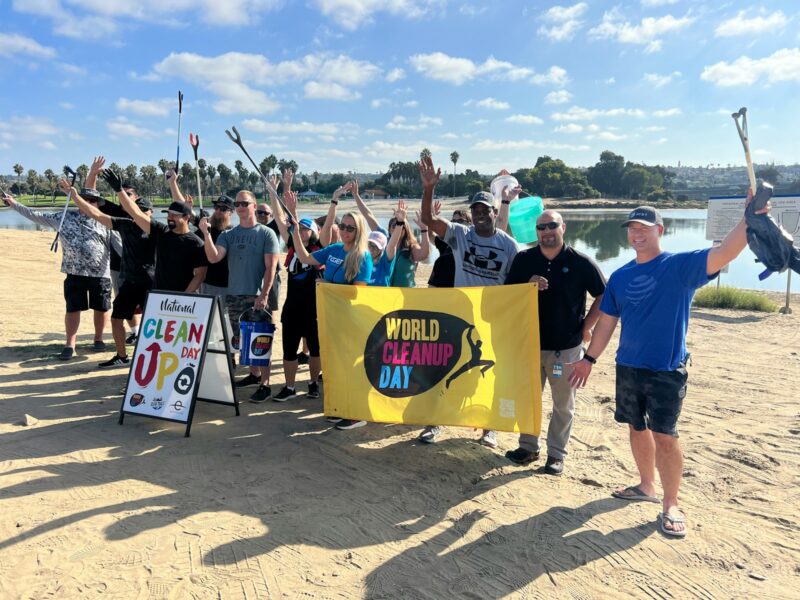 a group of people holding up a sign on the beach