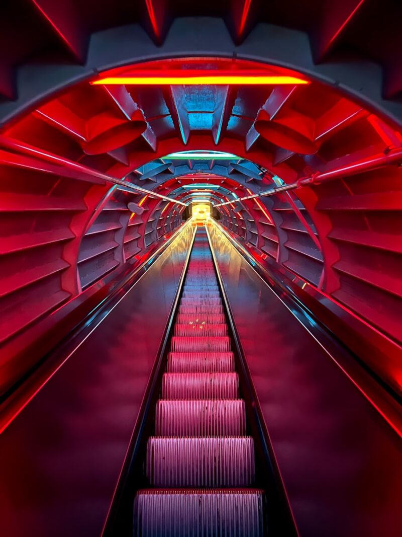 a red and blue tunnel with a long set of stairs