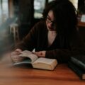 woman in brown long sleeve shirt reading book