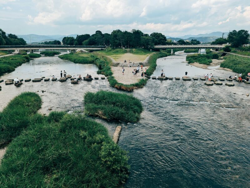 A group of people standing on top of a river